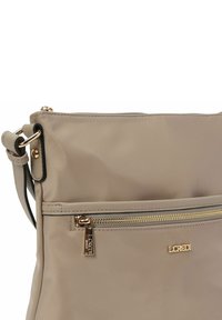 Beige Umhängetasche aus glattem Nylon, mit einer goldenen Reißverschlusstasche und eingeprägtem Logo, mit schwarzen Akzenten und einem abnehmbaren Gurt.