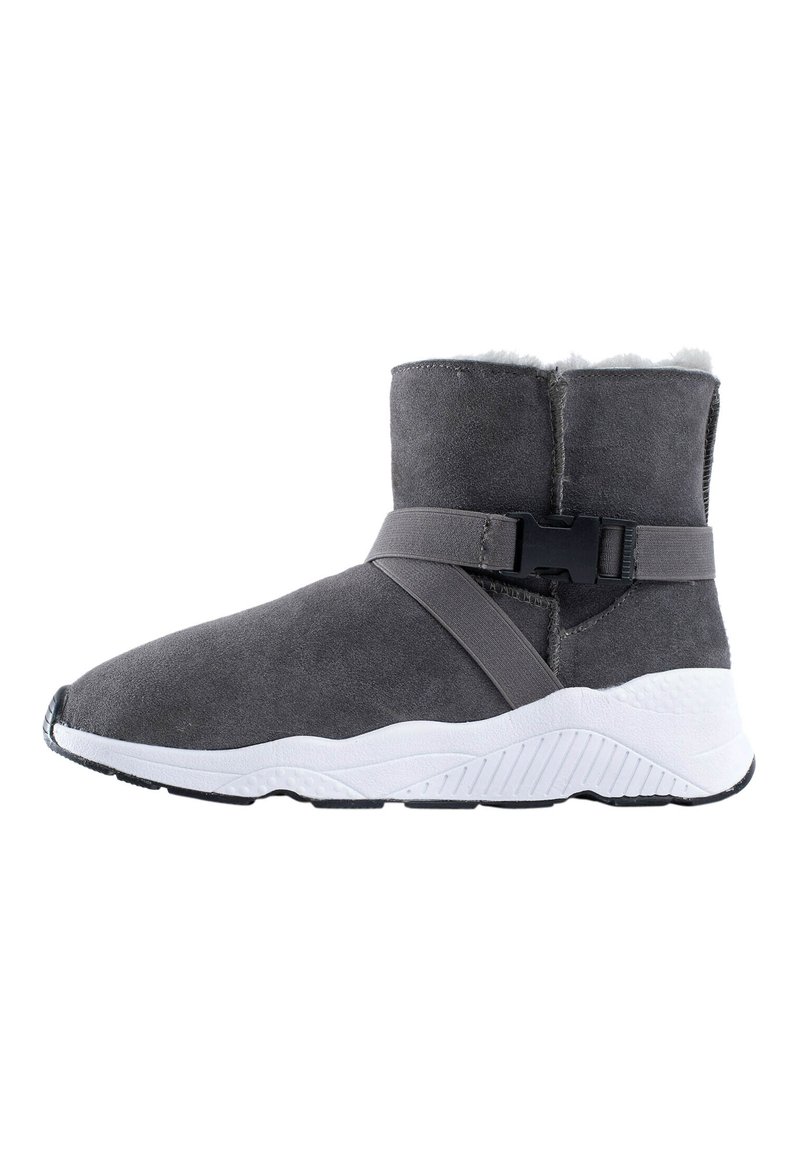 Bota de ante gris con suela de goma blanca, que presenta una correa cruzada y forro de felpa en la parte superior; diseño elegante y moderno.