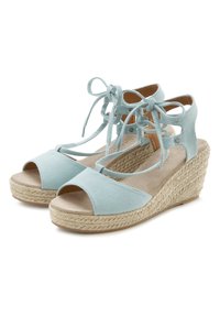 Svetlo modri, blazinasti sandali na peto z odprtim prstom, ki imajo zavezan trak okoli gležnja in tkane jute detajle na podplatu.