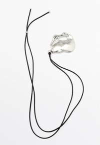 Collana in corda nera con un pendente in argento lucidato e texturizzato dalla forma organica e un'apertura centrale. Lunghezza regolabile.