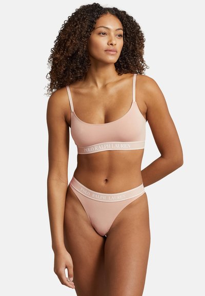 Bralette de canalé rosa claro con tirantes finos, que presenta una banda con el texto "POLO RALPH LAUREN". Tanga a juego de cintura baja con una marca similar.