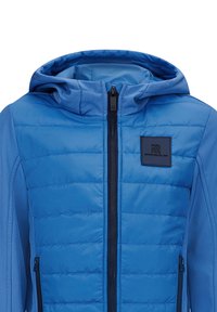 Veste bleue avec un devant matelassé et rembourré et des manches en tissu lisse, dotée d'une fermeture éclair, de poches latérales et d'un patch logo.