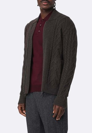 Cardigan in maglia a trecce marrone scuro con zip davanti, polsini e orlo a coste, indossato su una polo bordeaux. Texture morbida e motivo dettagliato.
