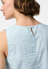 Svijetloplavi top bez rukava s kariranim uzorkom, zatvaranje na leđima u obliku ključanice s dugmetom i mekom, glatkom teksturom tkanine.