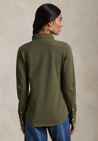 Olivovo zelená košeľa s dlhým rukávom, skladaným golierom, zapínaním na gombíky na manžetách a zaobleným lemom. Vyrobená z mäkkej látky s hladkou textúrou.