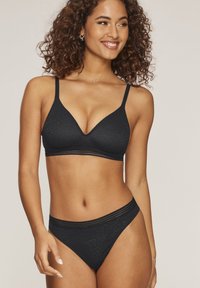 Schwarzes Lingerie-Set mit einem strukturierten, dreieckigen Bralette mit dünnen Trägern und passenden hochgeschnittenen Panties mit Spitze.