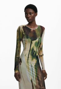Langärmliges Kleid aus leichtem, transparentem Material mit einem abstrakten Muster in Grün, Braun und Beige; taillierte Silhouette mit rundem Ausschnitt.