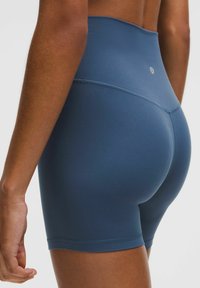 Hoge taille sportshorts in een donkerblauwe, gladde stof met een aansluitende pasvorm. Bevat platte naden en een klein logo-detail.