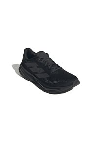 Scarpa da corsa nera con lacci, realizzata in materiale Gore-Tex e con logo a tre strisce sul lato, posizionata su uno sfondo bianco.