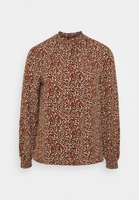 Pitkähihaine blouse ruskeasta kankaasta, jossa on värikäs eläinkuvio, korkea kaulus ja rypytys yksityiskohtia kaulan ympärillä.
