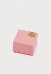 Boîte en carton rose carrée avec une texture lisse, présentant une étiquette circulaire dorée indiquant "Plaqué Or 18K" et un texte en relief lisant "pièces fines".