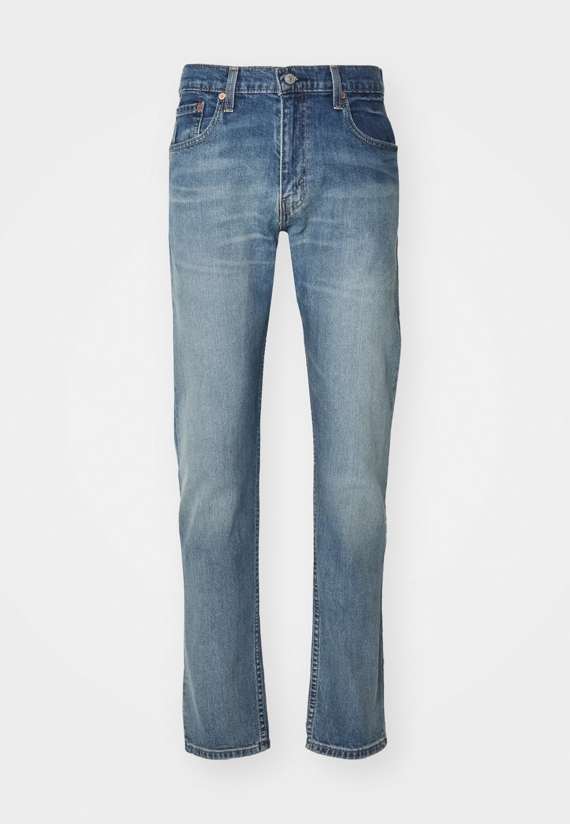 Jean en denim bleu avec une coupe droite, présentant un lavage délavé, cinq poches et une fermeture à bouton en métal à la taille.
