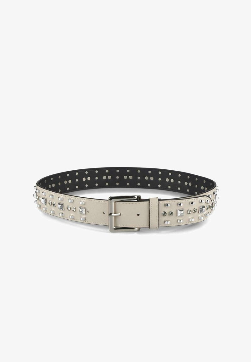 Ceinture en cuir beige avec des accents cloutés argentés et une boucle en argent ; surface texturée ; intérieur noir lisse avec des perforations circulaires.