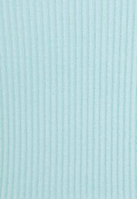 Tissu en tricot côtelé bleu clair avec des lignes texturées verticales créant un motif doux et extensible.