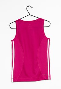 Fuchsia ärmlös träningstop, gjord av strukturerad tyg, med vita sidskåror och ventilationsdetaljer på baksidan. Hänger från en svart krok.