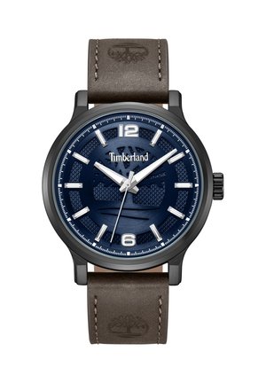 Ura Timberland z modrim teksturiranim številčnico, srebrnimi številčnimi oznakami, belimi kazalci, črnim ohišjem in rjavim usnjenim paščkom z vtisnjenim logotipom drevesa.