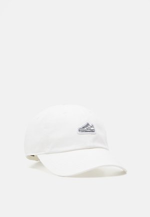 Boné branco de algodão com aba curva e logótipo bordado de sapatilha na frente. Apresenta seis ilhós de ventilação para respirabilidade.