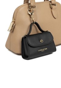 Borsa a tracolla beige con texture e hardware dorato, accompagnata da un piccolo portafoglio in pelle nera con patta e dettaglio del logo dorato.