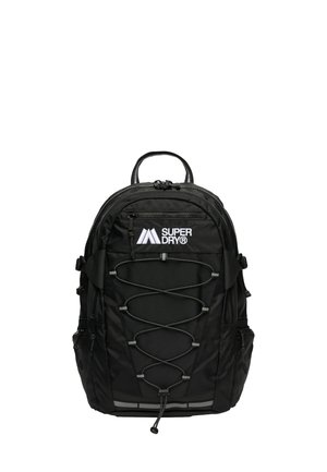 Mochila negra con una tela texturizada, dos compartimentos con cremallera, diseño de cordón elástico en la parte frontal y una asa de transporte en la parte superior. Presenta marca.