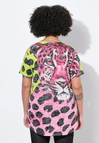 Short-sleeve T-shirt featuring a vibrant pink and black leopard design on a neon green background with a soft texture.