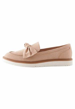 Chaussure slip-on en suède rose clair avec un accent en nœud à l'avant, présentant une semelle en caoutchouc blanc et un design à profil bas.