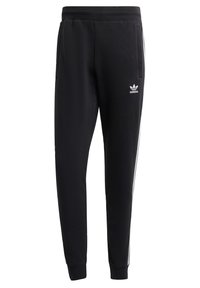 Svarta Adidas sweatpants med vit tre-stripes detaljer på sidorna, elastisk midja, sidofickor och Adidas trefoil-logotyp på vänster lår.