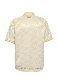 Korte mouw sportshirt in crème met een gestructureerd visgraatpatroon, gele kraag en "INTERNATIONALS" in goud aan de zoom.