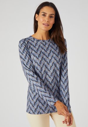 Langermige blauwe top met een geometrisch patroon van driehoeken in tinten blauw, grijs en roze. Zachte stoftextuur, ronde halslijn.