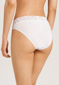 Ropa interior de algodón blanca con una cinturilla de encaje, diseño de tiro alto, textura suave y bordes sin costuras, mostrando la vista trasera y lateral.