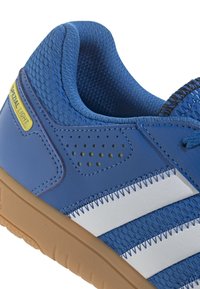 Baskets bleues en matériaux mesh et cuir, avec des rayures blanches en diagonale, un accent jaune portant l'inscription "SPECIAL LIGHT", et une semelle en gomme texturée.