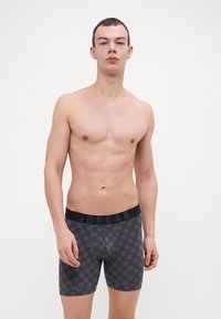 Boxeri negri-gri din material elastic, cu talie elastică. Prezintă un model geometric subtil. Confecționați dintr-un material elastic și neted.
