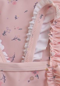 Rosa baddräktsfabric med blommönster; har volangband, mjuk textur och delikata sömnadsdetaljer.