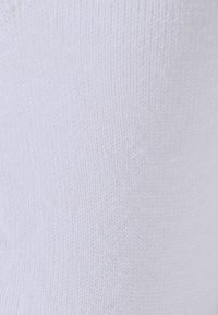 Weisse Baumwollsocke mit glatter Textur und engmaschigem Muster, das einen leichten Glanz und eine gleichmäßige Oberfläche für Komfort zeigt.