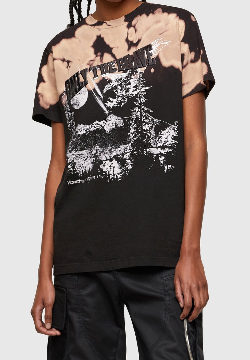 Černé tričko s batikovaným vzorem a grafickým designem, který zobrazuje hory, stromy a nápis "JEN PRO ODVÁŽNÉ" tučným písmem.