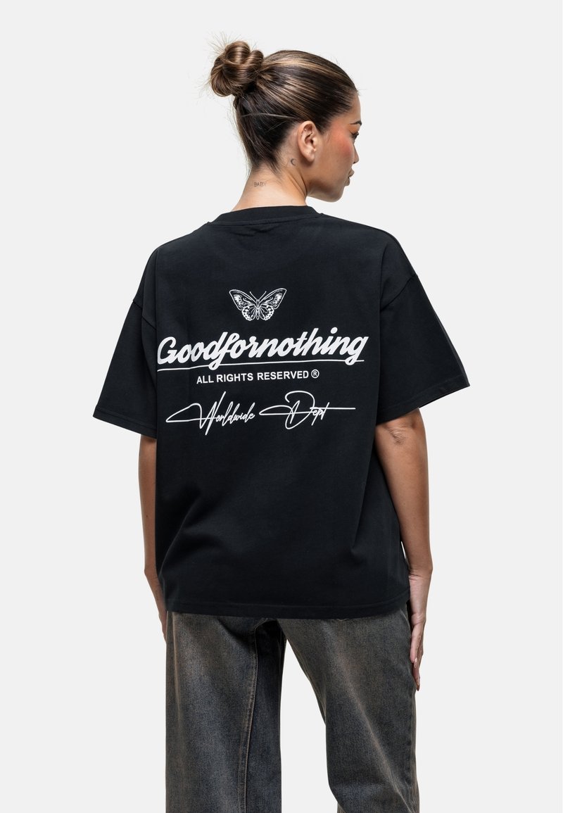T-shirt en coton noir oversize avec texte blanc et motif de papillon au dos, à manches courtes et à la coupe décontractée.
