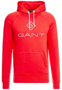 Sweat à capuche rouge en tissu doux, avec une poche kangourou devant, des cordons blancs, et le logo "GANT" brodé sur la poitrine.