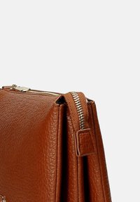 Borsa in pelle marrone con finitura testurizzata, dotata di chiusura a zip, dettagli cuciti e manico laterale per il trasporto.