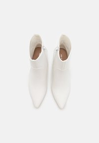 Weiße Ankle Boots mit spitzem Zehenbereich, glattem Leder, seitlichem Reißverschluss und passendem Innenfutter. Einfaches, elegantes Design.
