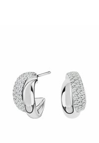 Srebrne kolczyki w kształcie obręczy z zakrzywionym wzorem, wysadzane przezroczystymi kryształami z przodu, odbijającymi światło i dodającymi blasku.