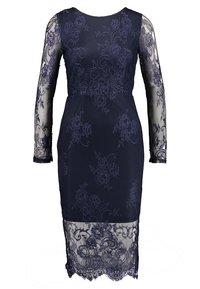 Marinblå spetsklänning med långa genomskinliga ärmar, blommiga mönster och en figursydd siluett. Har en spetsfåll och en rund halsringning.