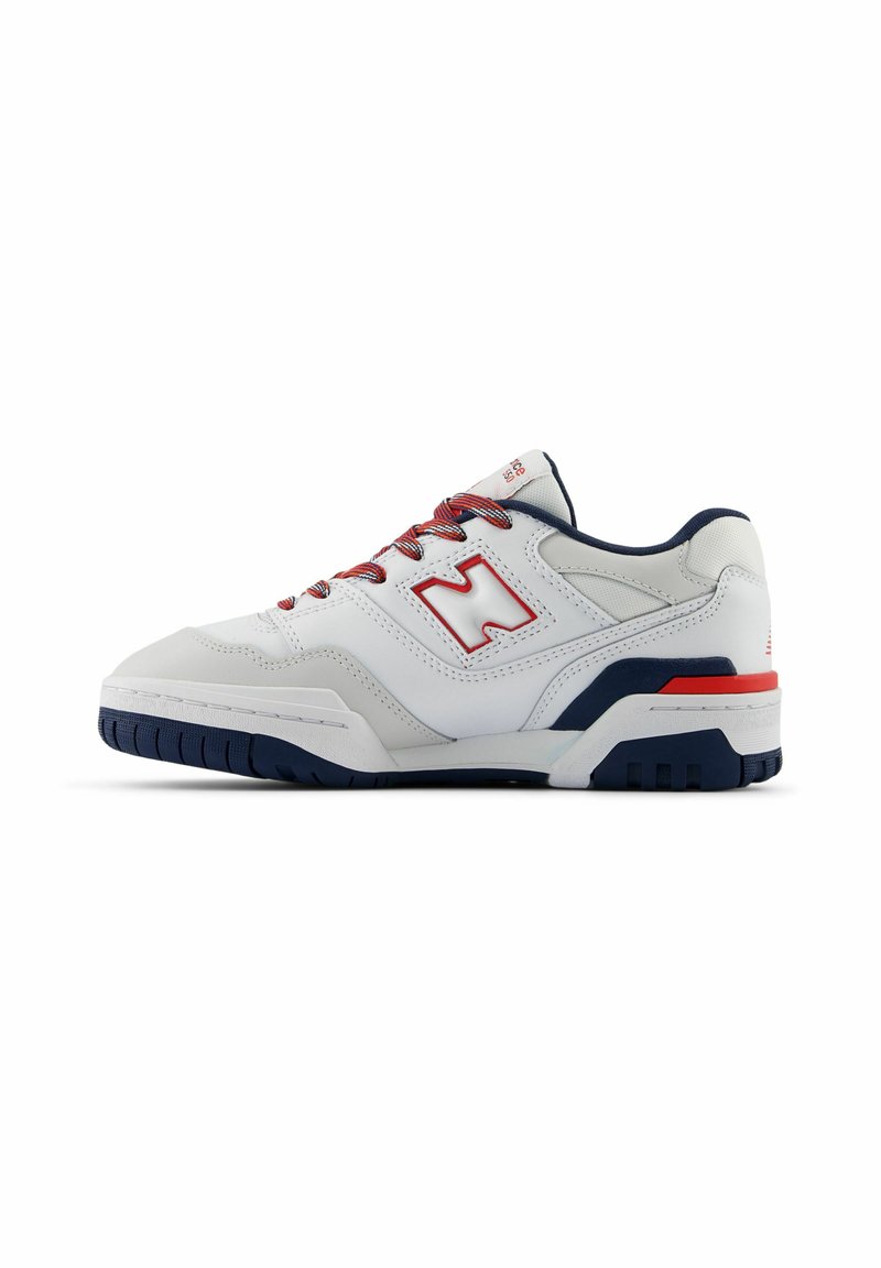 Chaussure de sport blanche avec des accents rouges et bleu marine, design à lacets, tige en cuir texturé et semelle en caoutchouc avec des rainures de traction.