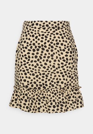 Beżowa spódnica z nieregularnymi czarnymi grochami i falbanką u dołu.