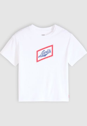 Biała koszulka z krótkim rękawem z diamentowym logo z czerwonym obramowaniem i niebieskim napisem "Levi's" na środku klatki piersiowej.