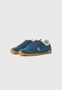 Blue suede sneakers with a rubber sole, featuring a contrasting light-colored collar and subtle logo detail on the side.