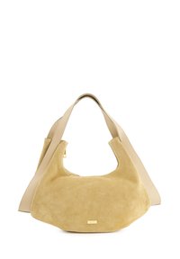 Beige semišová kabelka s hladkým koženým popruhem. Zakřivená silueta, velké otvory. Zlato tónové detaily na přední straně. Měkká textura.