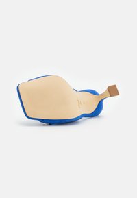 Chaussure à talon haut en daim bleu avec une semelle beige texturée. Le talon a une forme carrée avec un design minimaliste, présentant un léger accent surélevé.