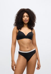 Čierna hlboká podprsenka s nastaviteľnými ramienkami, doplnená čiernymi tangami s šedým elastickým pásom s potlačou "KARL LAGERFELD".