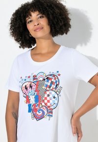 Hvid bomulds-t-shirt med et farverigt grafisk design med hjerter, mønstre og ordet "ANGEL", fremhævet af stjerner og legende ikoner.