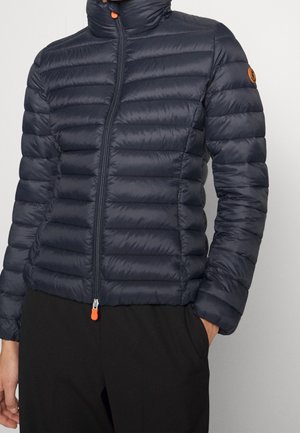 Mørkeblå quiltet dunjakke med høj krave, fuld lynlås foran med orange trækflig og lille orange logo patch på venstre ærme.