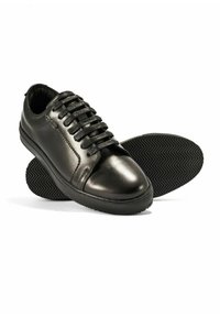 Czarne skórzane trampki z okrągłym noskiem, wiązane, z teksturowaną czarną gumową podeszwą o wzorze w jodełkę oraz gładkim wykończeniem.